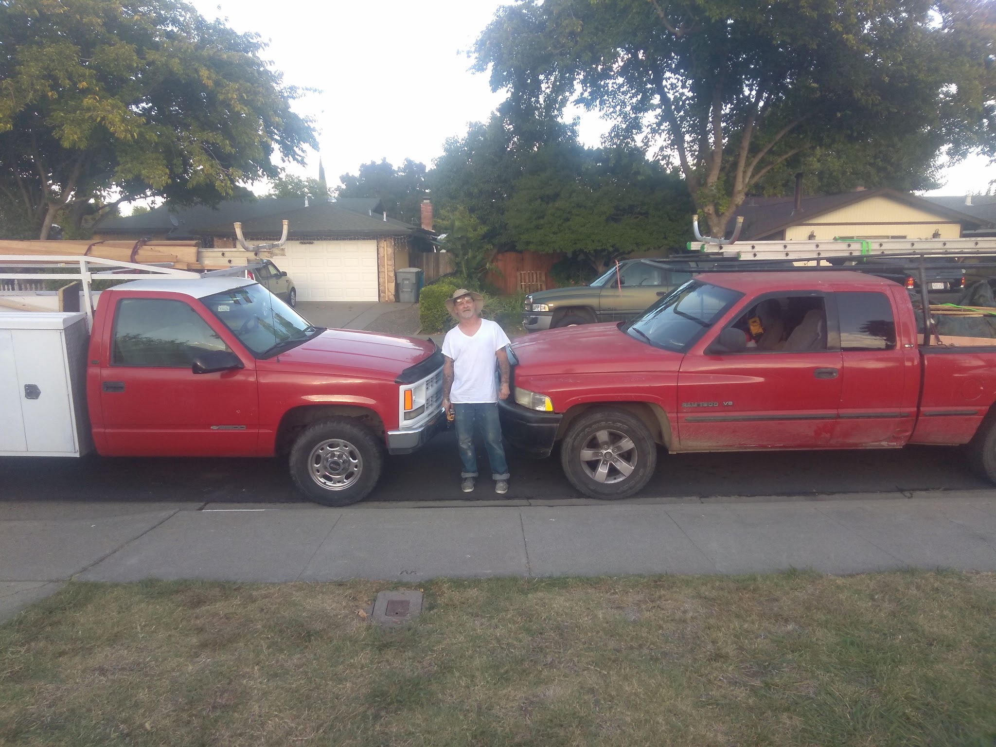 Bob of Romack Home Maintenance standing between his two loaded work trucks